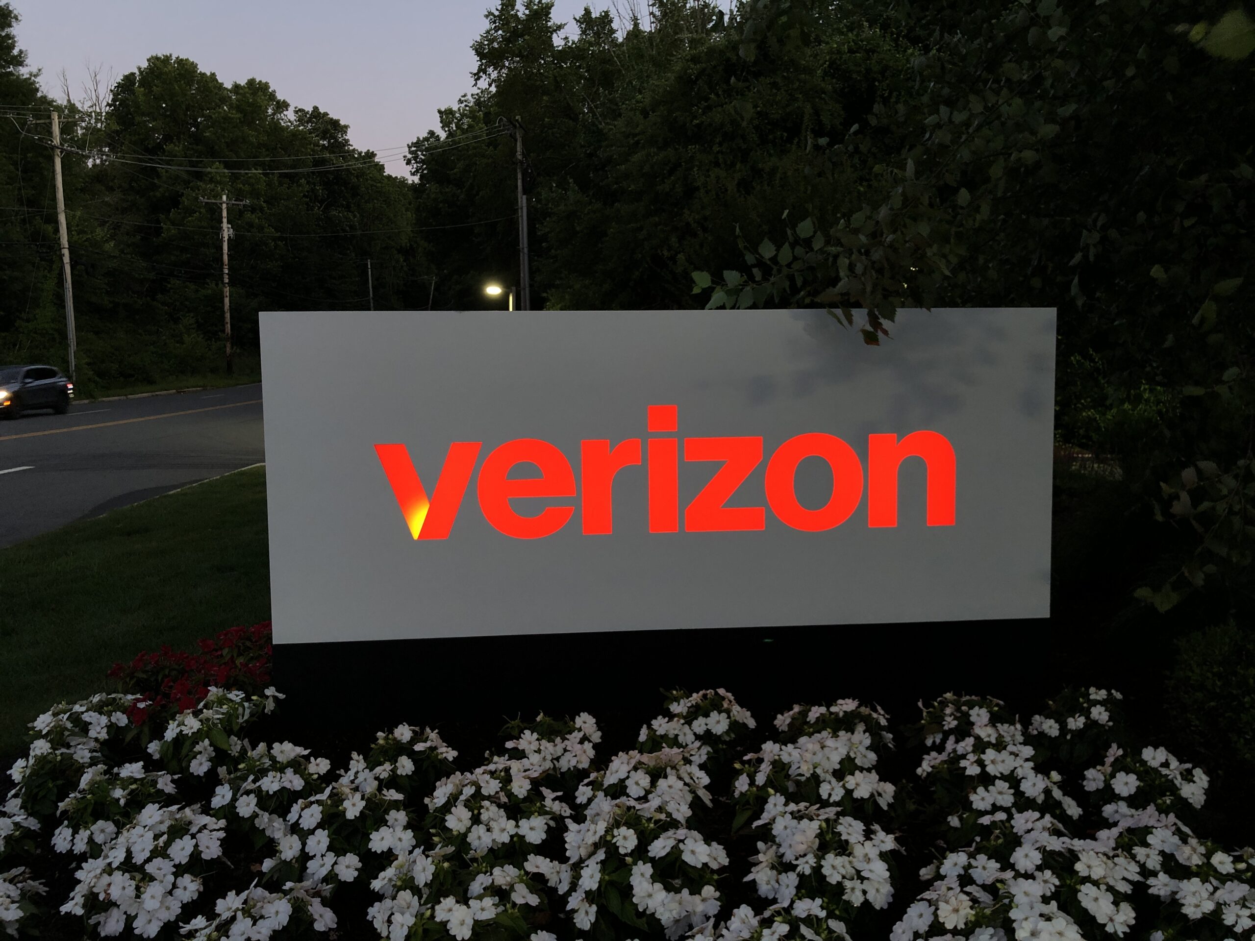 A mounted illuminated sign outside a Verizon location.