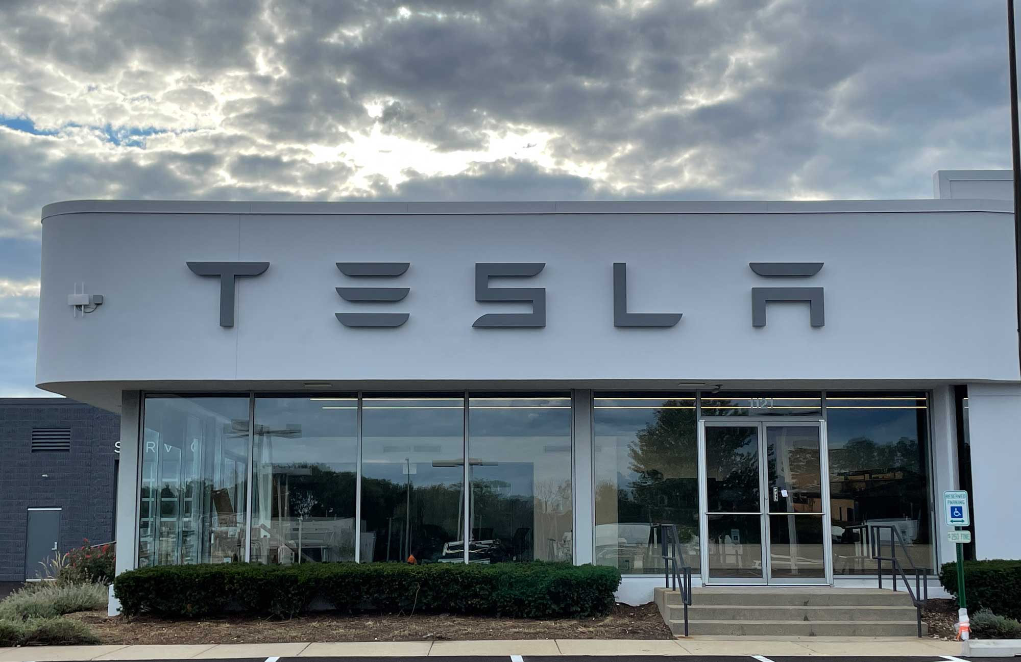 Exterior of a Tesla dealership featuring signage by Identiti.