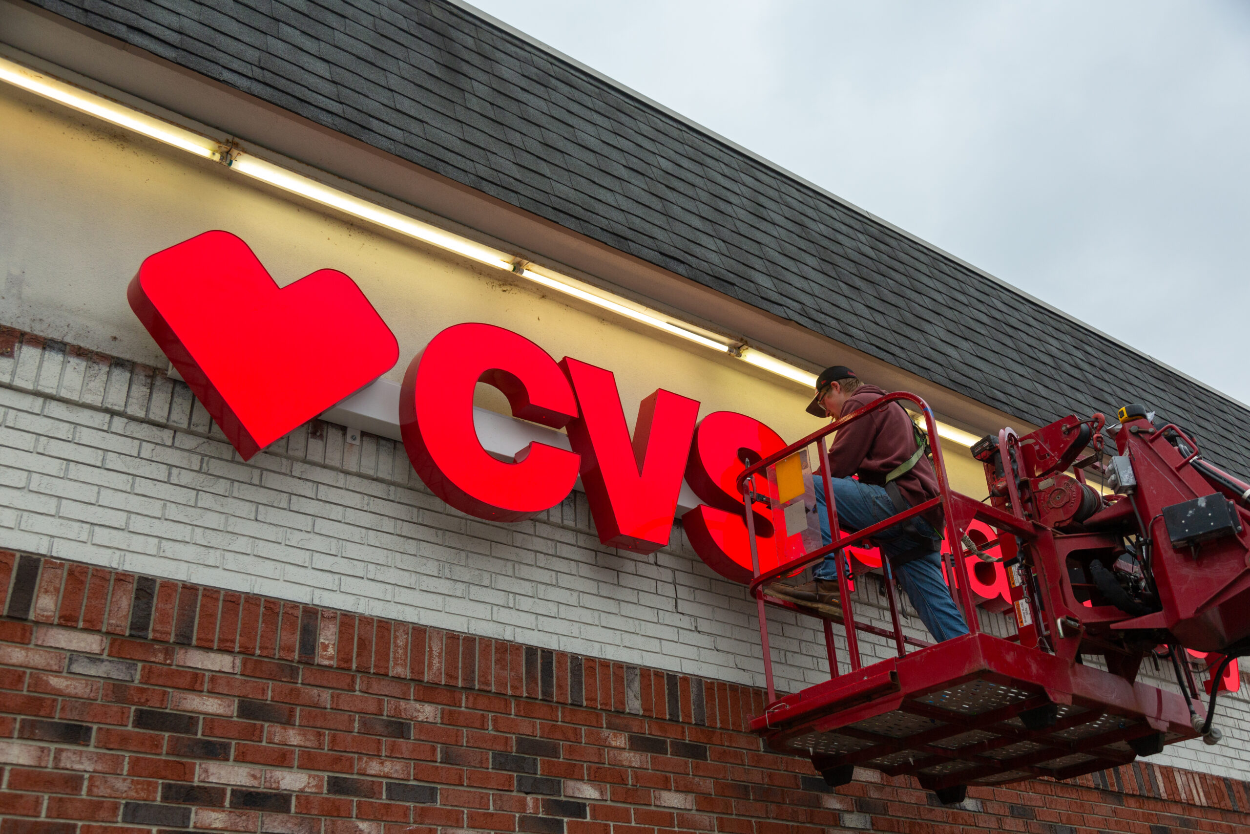 An Identiti installation partner working on a large CVS Pharmacy exterior sign.