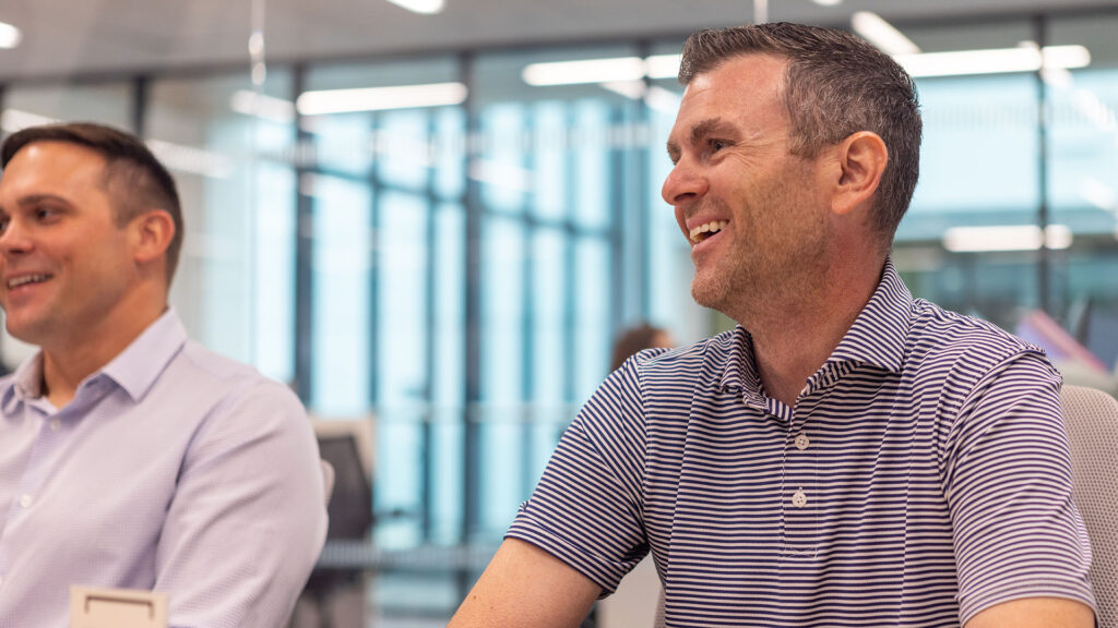 Identiti leadership smiling during a team meeting.