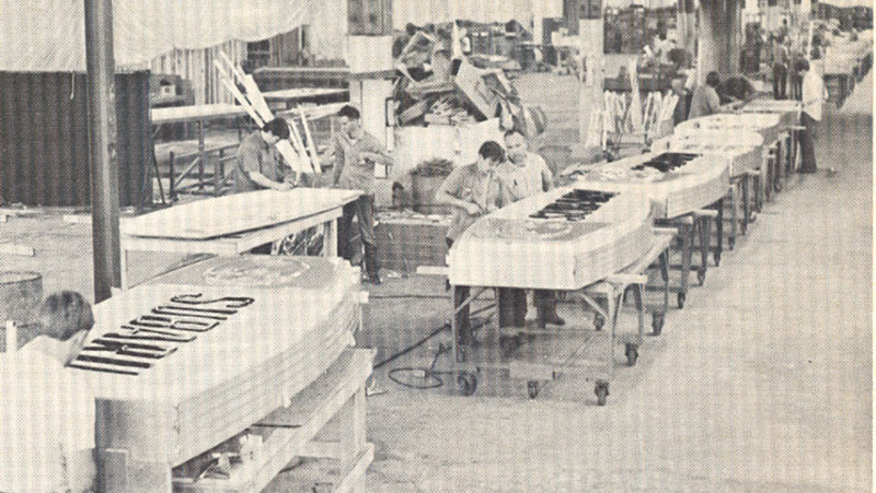 Historical photo of the Cummings Signs factory floor where workers are preparing Subaru signage for dealerships nationwide.