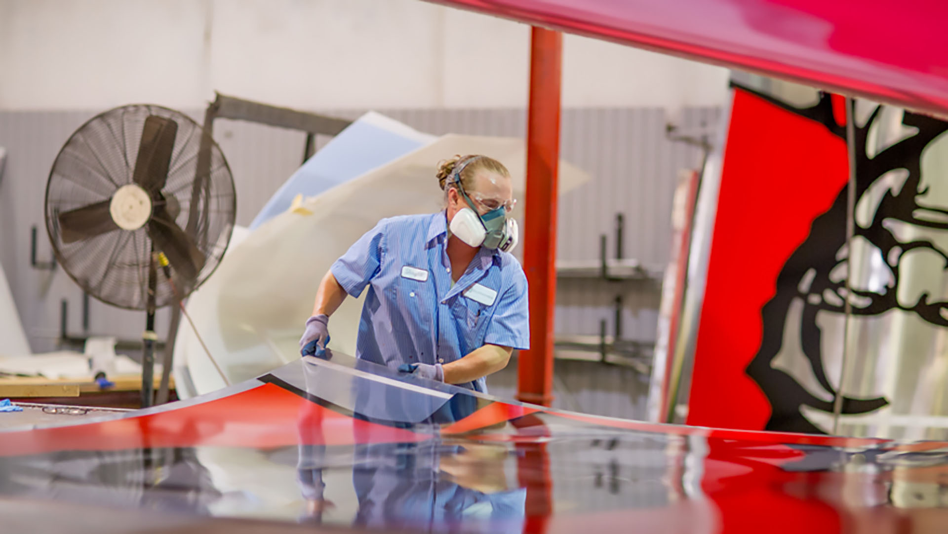 A worker removing a fully fabricated KFC sign facet from the factory floor.