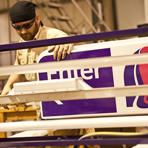 An Identiti manufacturing employee works on a Taco Bell directional sign.