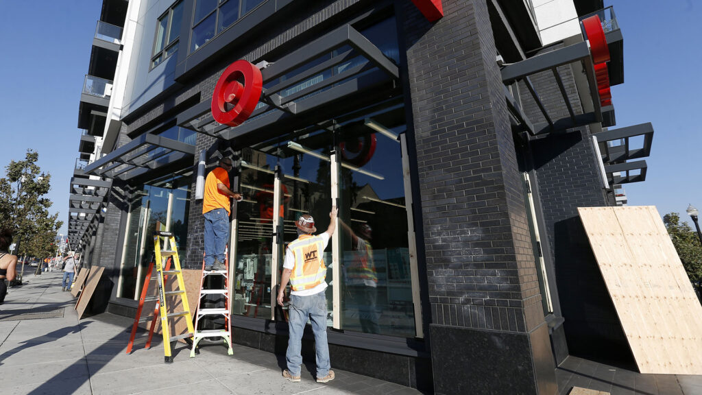 Two Identiti professionals working on new signage for an urban Target location.