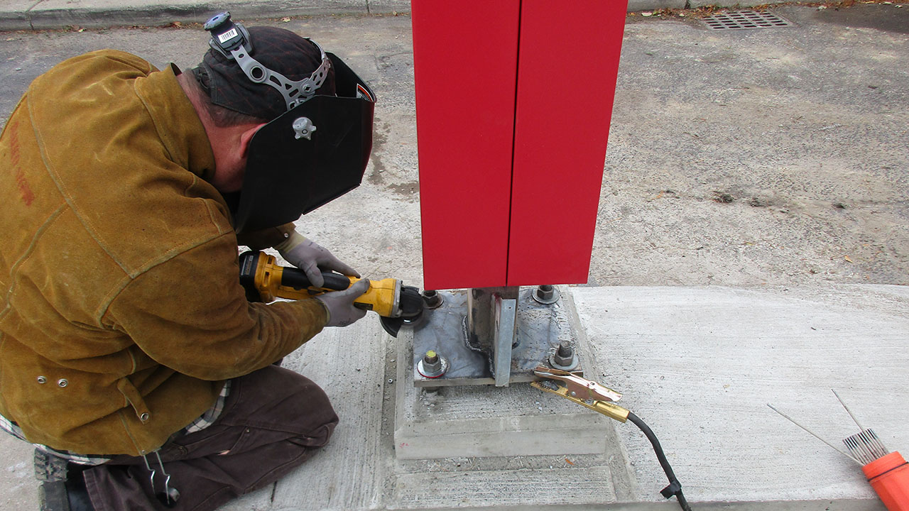 An Identiti vendor adding final touches to a freshly installed freestanding signage element.
