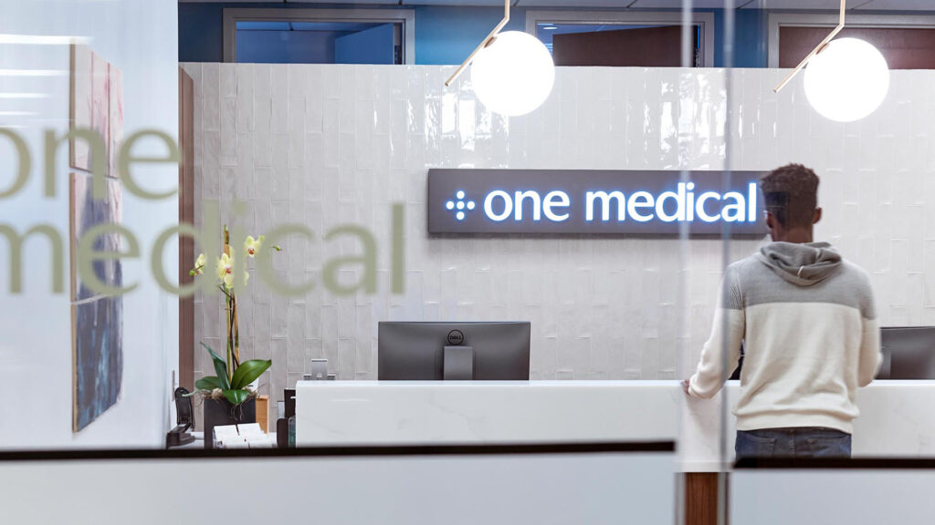 Interior branding for One Medical, featuring window appliques and receptionist area branding elements, all by Identiti.