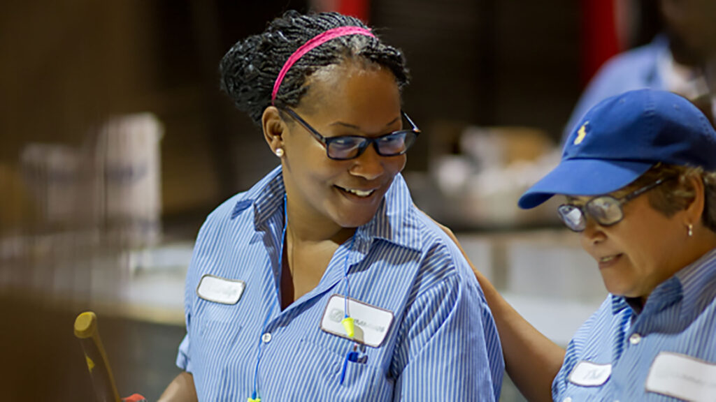 Two Identiti manufacturing employees work together.