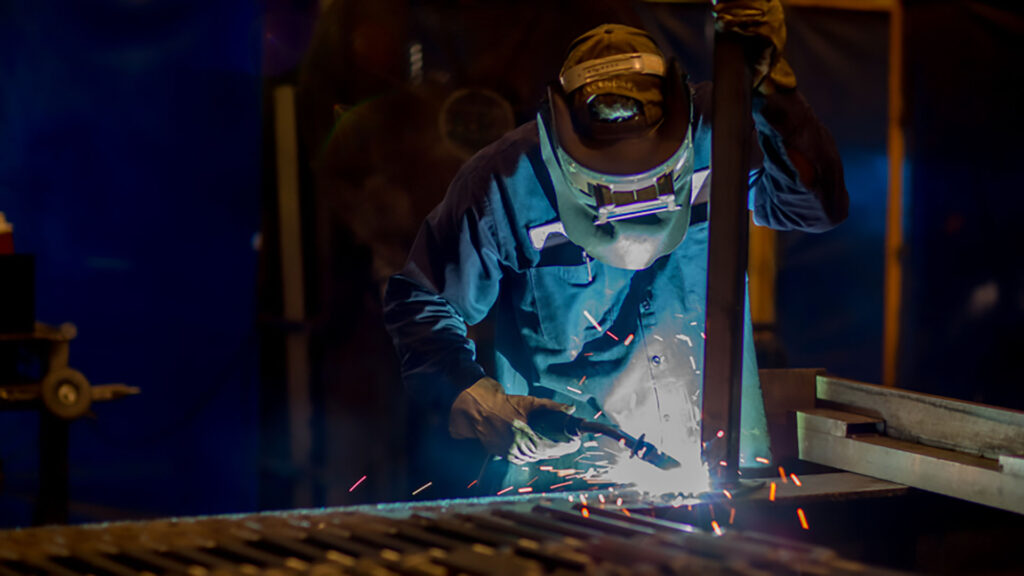 A welder working on a new signage element.
