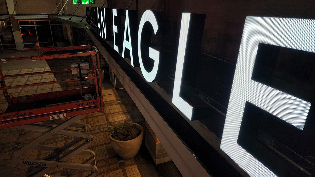 Illuminated signage atop an American Eagle storefront.