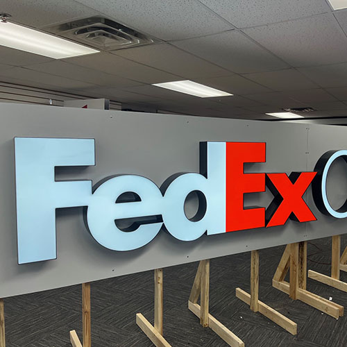 A large FedEx Office illuminated sign, developed by Identiti and set up for demonstration.