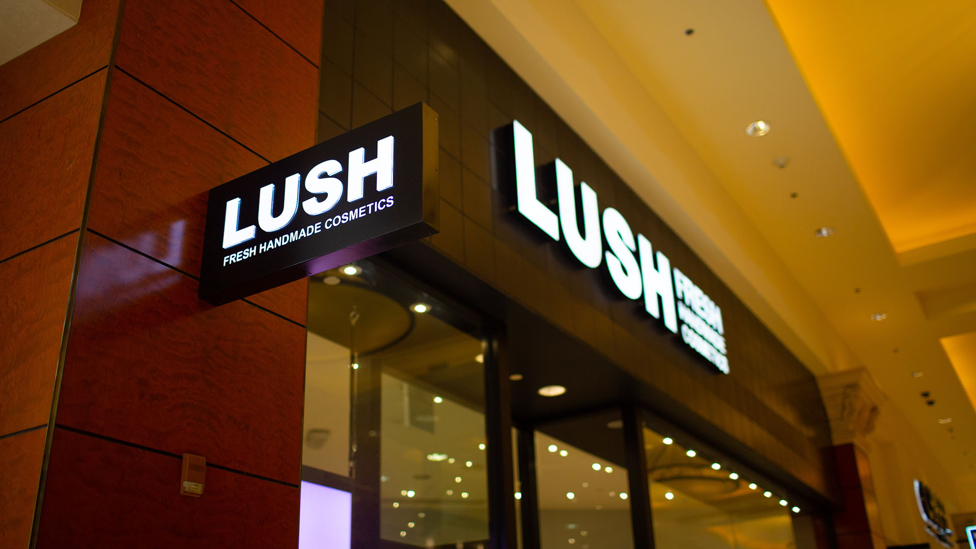 A Lush mall location featuring illuminated signage elements by Identiti.