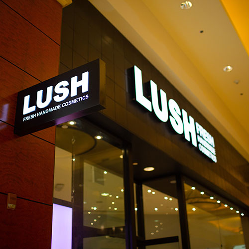 A Lush storefront, featuring illuminated signage types by Identiti.