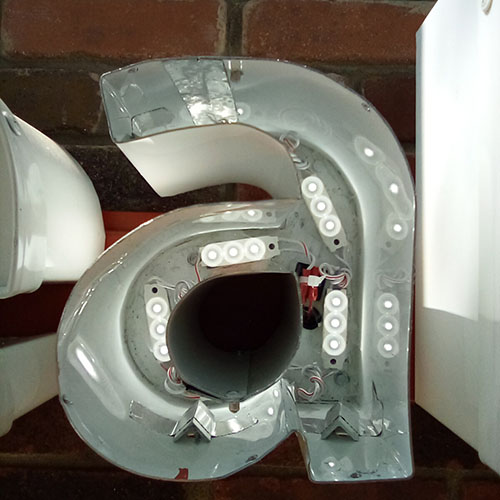 The interior of a channel letter with exposed lighting elements.