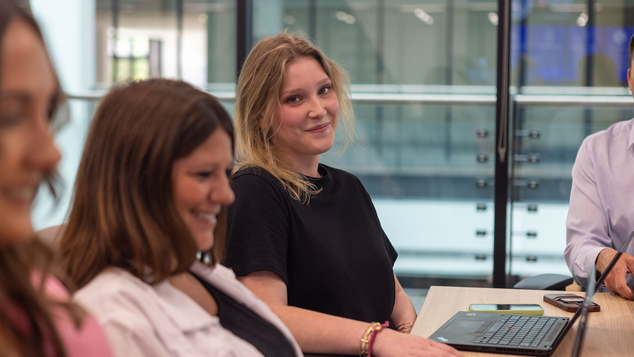 An Identiti team member smiling into the camera during a team meeting.