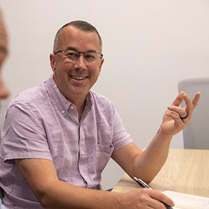 An Identiti designer taking careful notes during a meeting.